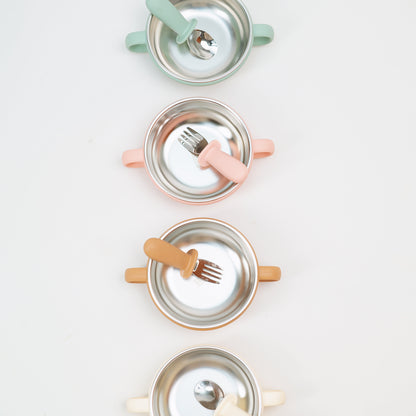 Set of four children's plates with cutlery on a white background